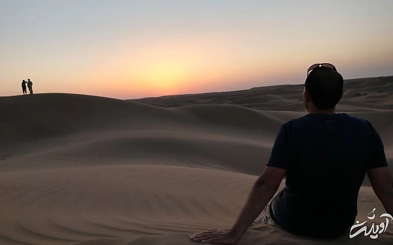 گردشگری در حال تماشای غروب خورشید در کویر مصر